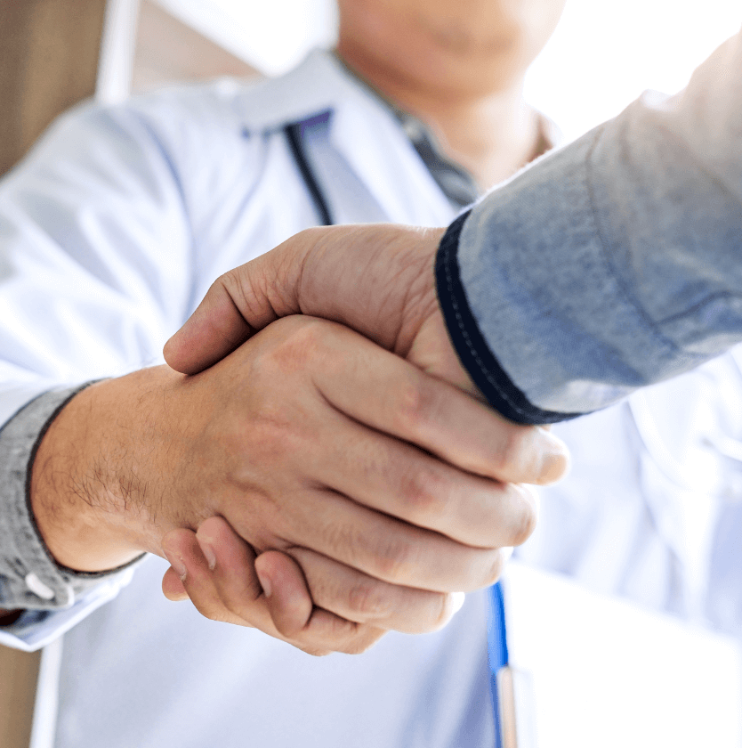 Closeup of a handshake between a dentist and a patient