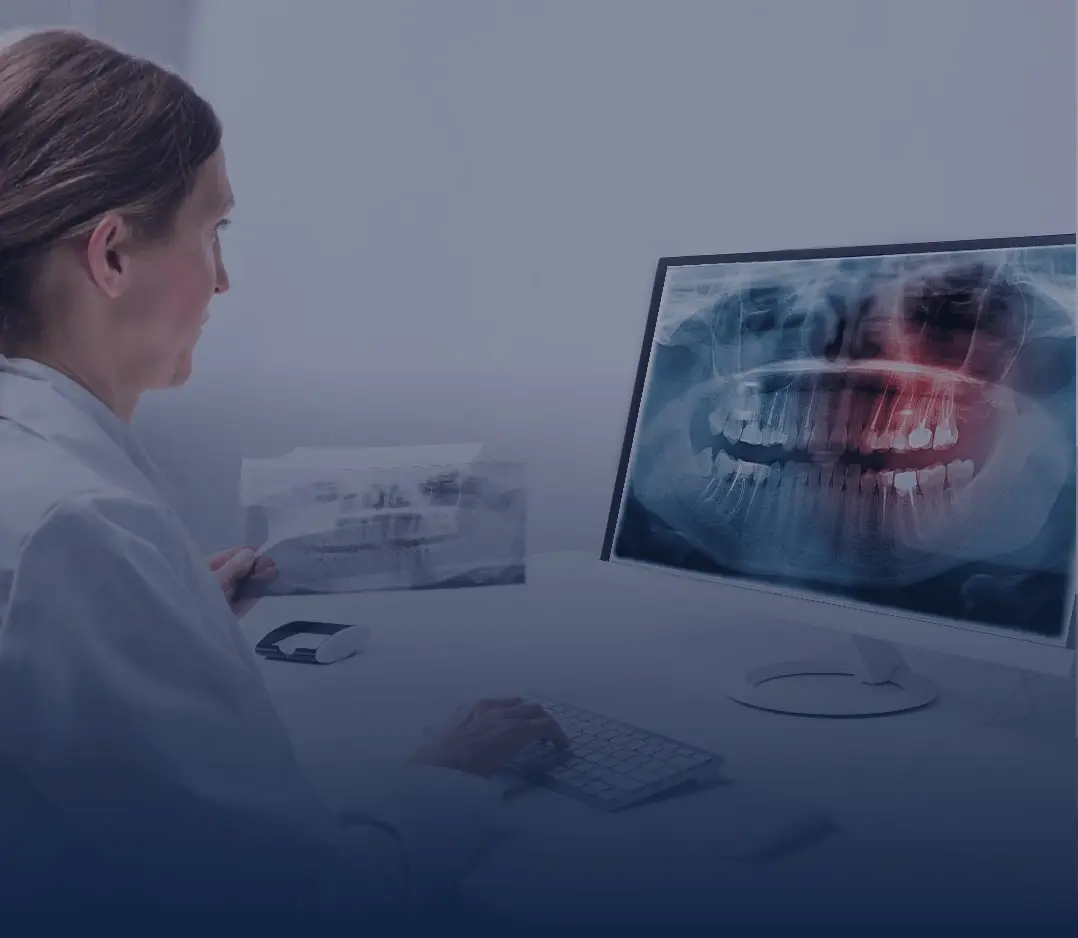 Female doctor looking at a dental x-ray on a computer monitor