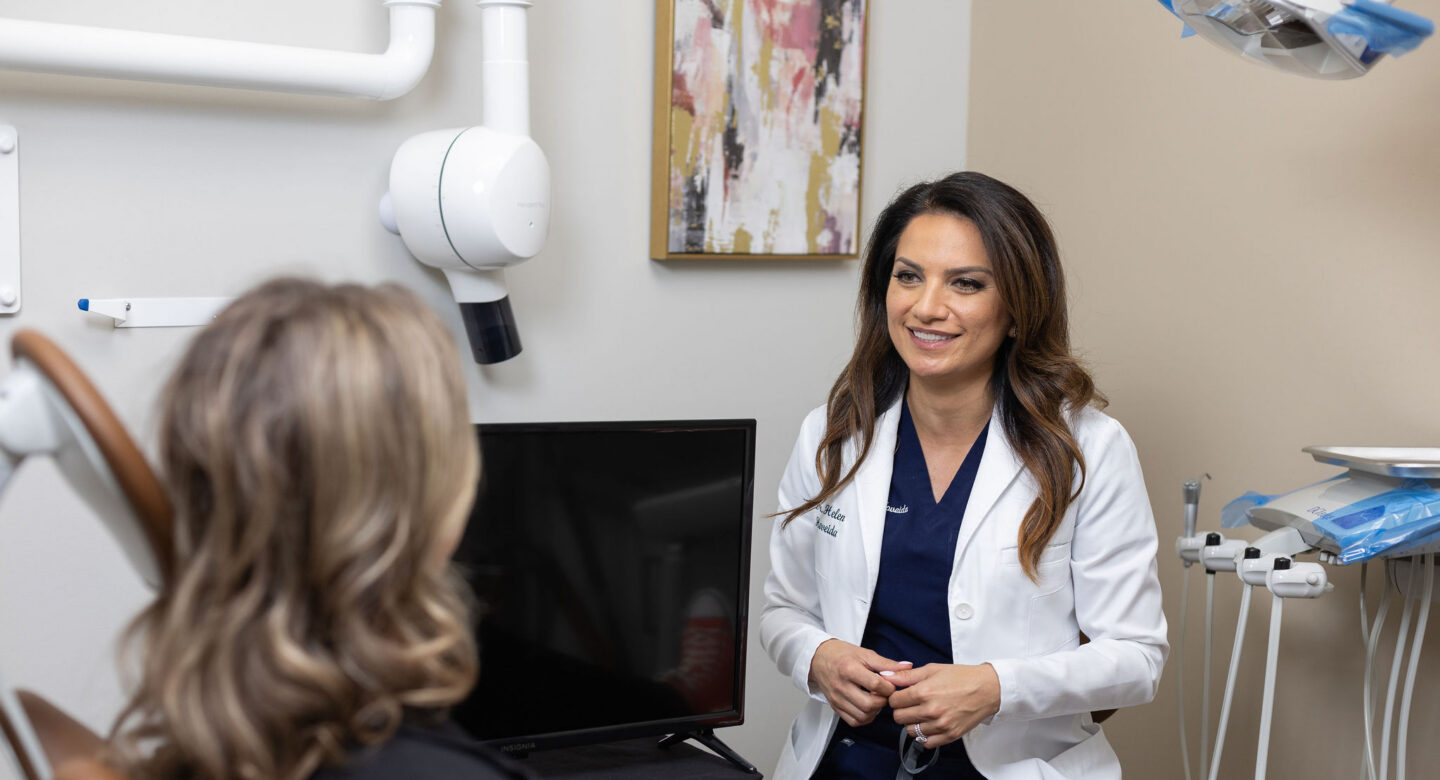 woman in dental office with lady in char