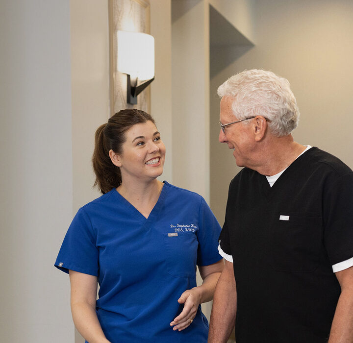 Two people in scrubs talking in a hallway, alternate cropping